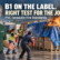 Illustrative cargo-fire scene for PVC tarpaulin fire standards: Duletai presenter, burning tarp-covered goods, extinguisher responders and a regretful buyer. B1 on the label. Right test for the job?